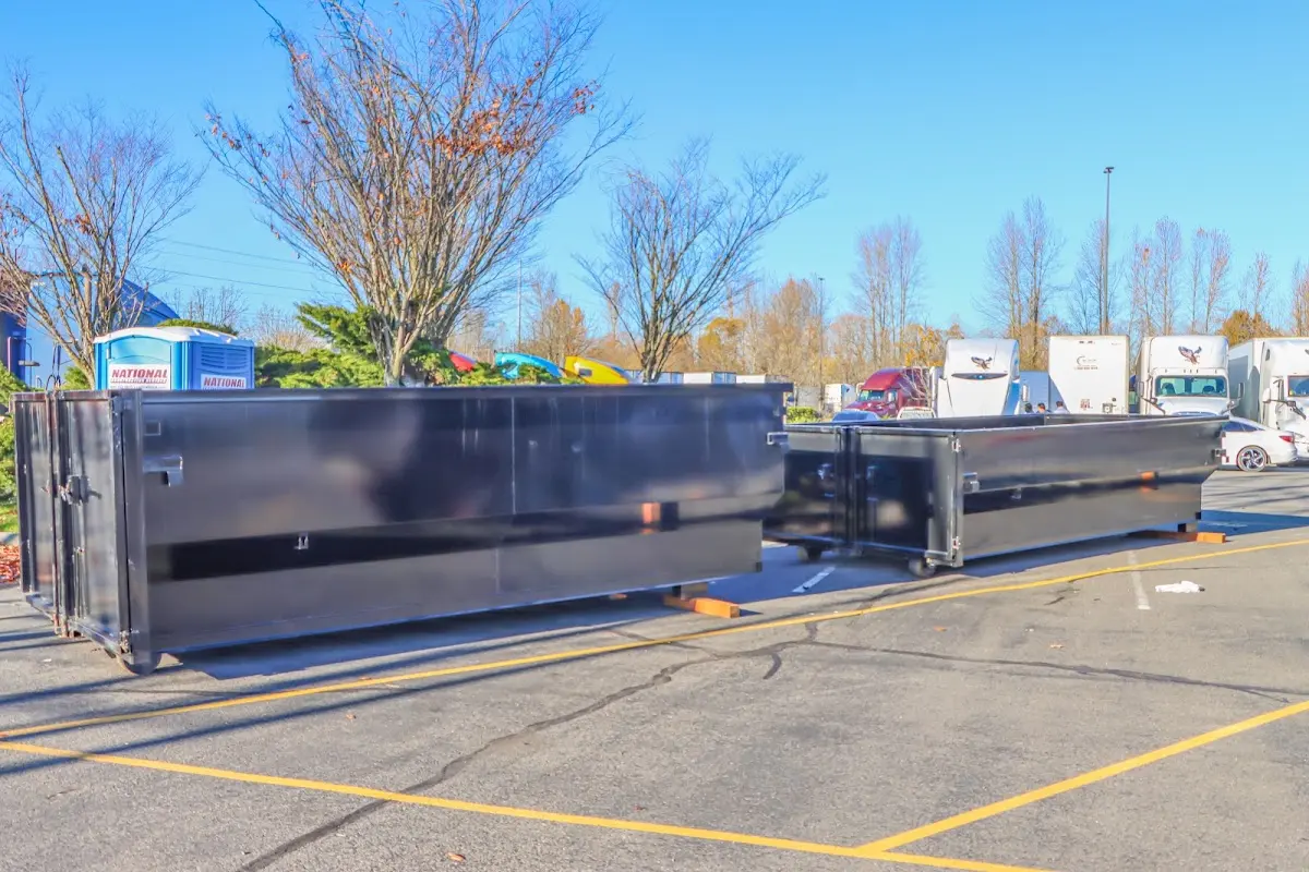 Professional dumpster rental service with roll-off container on residential driveway in The Village